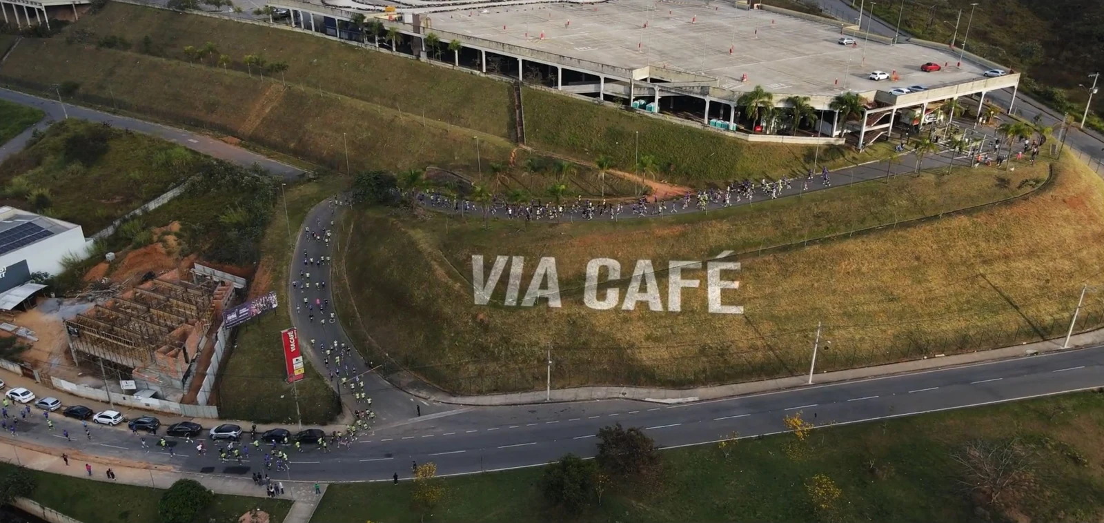 Frame da abertura: título Via Café integrado à imagem aérea do percurso da corrida